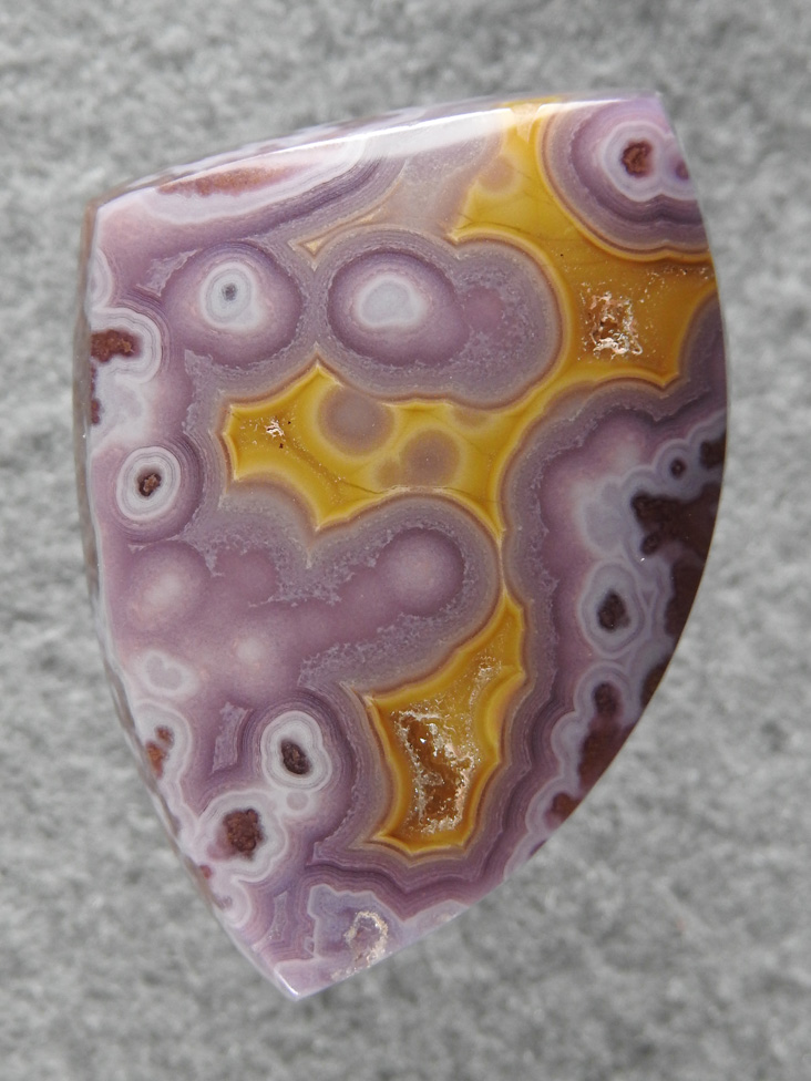 Coyamito Agate 144  :  Reminds me of the tops of crazy lace but in a stunning Purple Yellow.  An awesome cab to be sure.