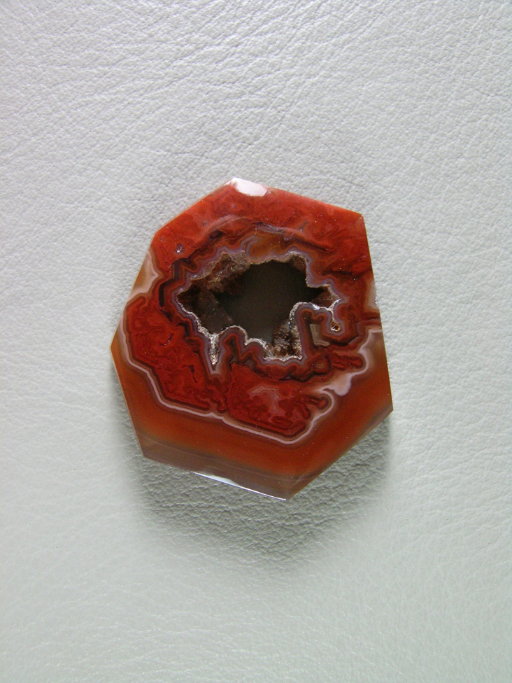 Coyamito Agate 210  :  A cab of exceptional Psuedomorph Agate from Coyamito in Cherry Reds. The cab follows the negative left by the Aragonite crystal form nicely, perfect for a pendant