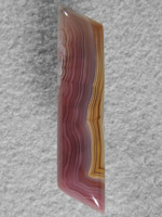 Coyamito Agate 212  :  A half dome elengated Barrel shape I like to cut when I find material that justifies it and this is the perfect material in it's lush Purples and Gold and tight bands.