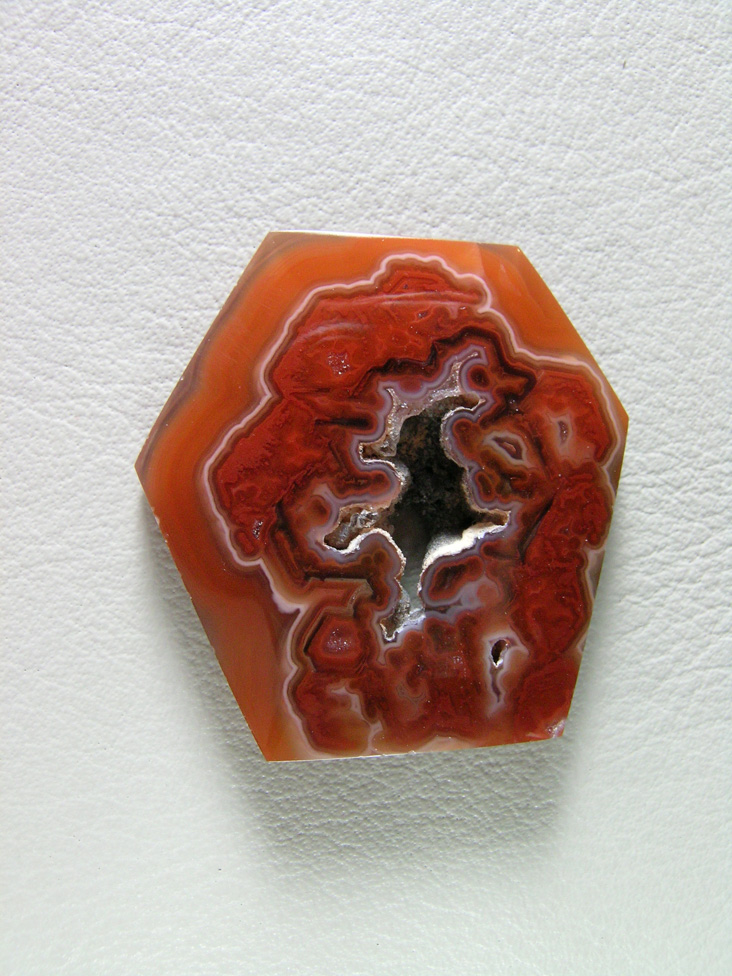 traded Coyamito Agate 255T  :  A cab of exceptional Psuedomorph Agate from Coyamito in Cherry Reds. The cab follows the negative left by the Aragonite crystal form nicely, perfect for a pendant