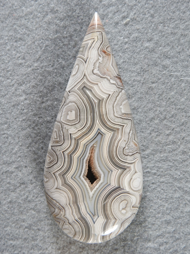 Crazy Lace Agate 686  :  A large teardrop in White completely framed around a fortification and druzy pocket.  This stone has a stunning shadow effect that just shimmers.