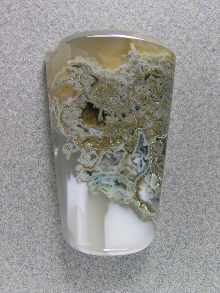 Horse Canyon Moss Agate 747  :  Moss center with think White Opal bands at the base and an amber Agate at the top on the ellongated Bola cab.