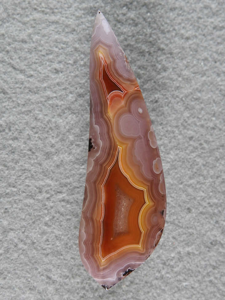 Laguna Agate 7  :  What great colors.  I wanted to keep the visual of that stringer leading to the top of the stone and that small Red pocket in the cutting.  Framed by those pink fluffs this stone turned out just perfect.