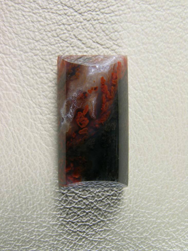 Walker Ranch Plume 481  :  A dark cab with Black Plumes running up to Red tips.  A smaller barel cab shape for a pendant or ring.