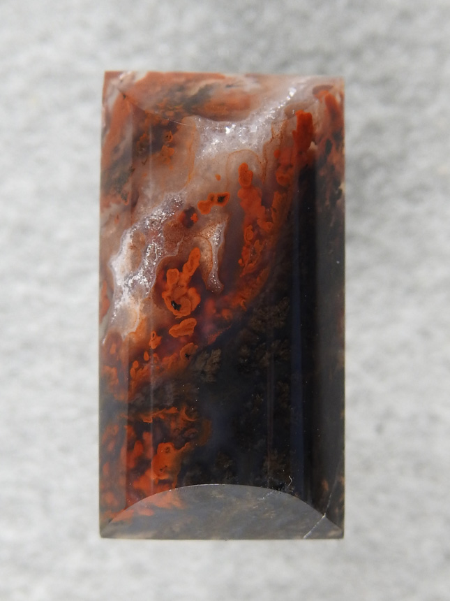 Walker Ranch Plume 481  :  A dark cab with Black Plumes running up to Red tips.  A smaller barel cab shape for a pendant or ring.